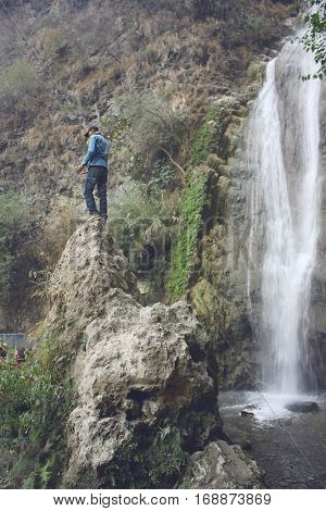 Traveler standing on a rock near waterfall in azad Kashmir Pakistan