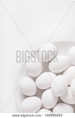 White eggs on a white plate on a white background. Eggs. Easter photo concept. Copyspace