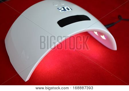 Nail gel salon. Beautiful woman hand and lamp UV  for nails UV with timer