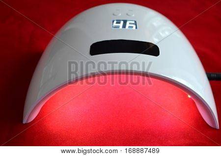 Nail gel salon. Beautiful woman hand and lamp UV  for nails UV with timer