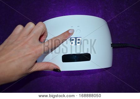 Nail gel salon. Beautiful woman hand and lamp UV  for nails UV with timer