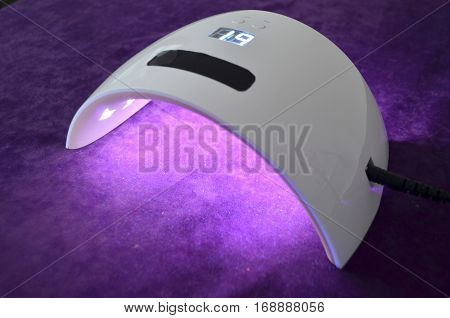 Nail gel salon. Beautiful woman hand and lamp UV  for nails UV with timer