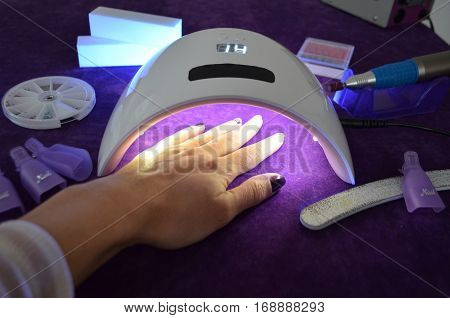 Nail gel salon. Beautiful woman hand and lamp UV  for nails UV with timer