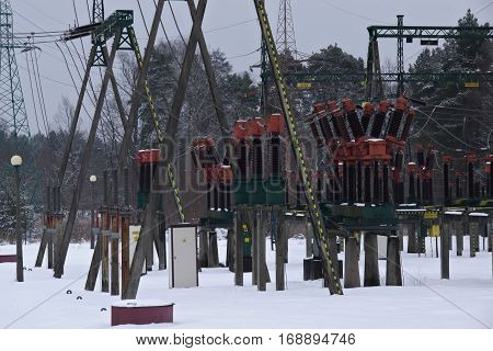 The photo shows the installation of terrestrial stations electro energy. In the photo are visible pillars of odgromnikami, power lines and ceramic insulators. It is winter, Teran stations cover layer of snow.
