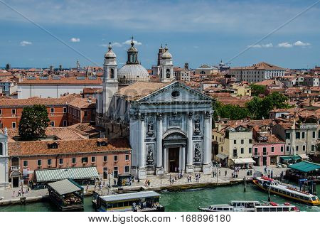 Tourists visiting the Saint Maria of Gesuati church on the grand canal in Venice, Italy centered in a seafront of colors and varied architecture