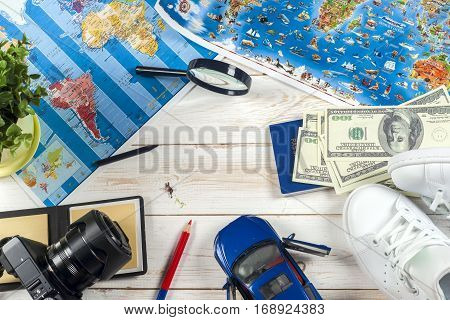 Travel - concept. Traveler's accessories Essential vacation items camera touristic maps on the white desk. Travel background. Car journey planning. Tourist essentials. Space for text
