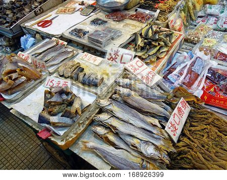 North Point, Hong Kong - February 13, 2016: Booth with various seafood on the Java Road Market in North Point, Hong Kong. At the stall of fresh, smoked, dried and packaged seafood is offered. The goods are marked with large price tags.