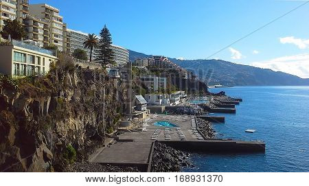 Coastal rocky line of hotels in Funchal the mountains the ocean. Madeira Portugal