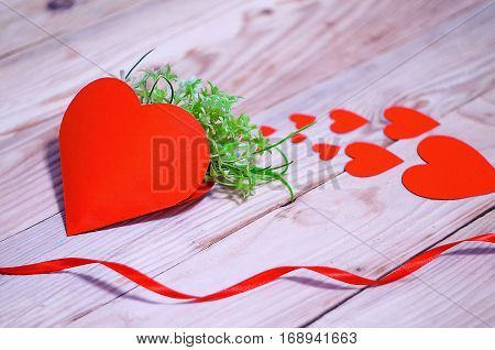 Hearts flowers ribbons on a wooden light background