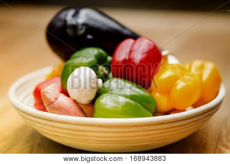 fresh vegetables and pasta lying on a wooden table.