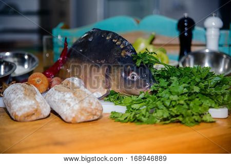 fresh vegetables and fish lying on a wooden table.
