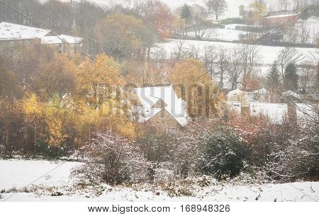 Houses sit under a blanket of freezing snow in the British countryside.