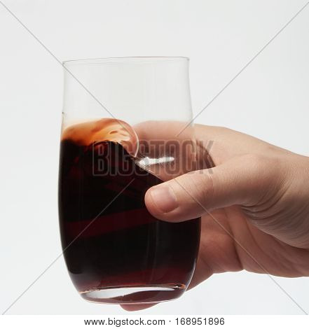 Macro of red wine in stemless glass isolated on white background. Wine beverage
