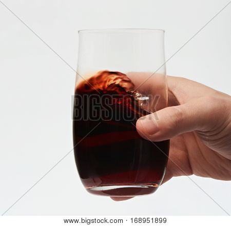 Close up of red wine in stemless glass isolated on white background. Testing red wine. Move red wine