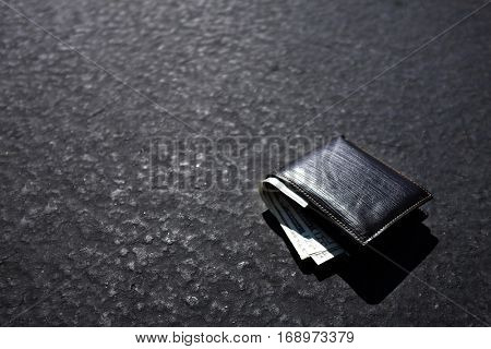 Lost wallet lying on street or roadway road path with cash