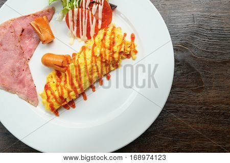 Top view omelet with ham breakfast menu on white dish with wooden background