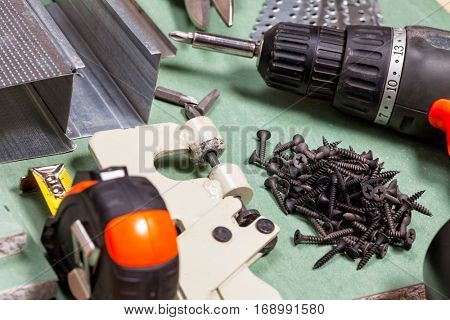 Plasterboard tools set with metal studs, screws, tape measure, screwgun and punch lock crimper