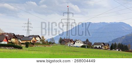 Panoramic View Of The Alpine Village Unterburg With The Power Transmission Line Tower In The Foregro