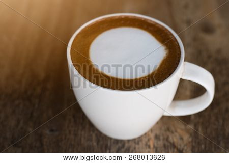 Hot Coffee With Foam Milk On Wooden Background.