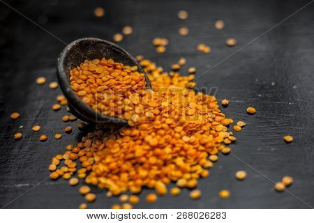 Close Up Of Raw Masur Dal Or Masoor Lentils Or Pink Lentils In A Black Colored Clay Bowl On Wooden S