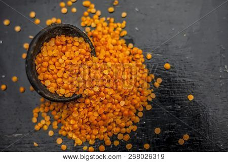 Close Up Of Raw Masur Dal Or Masoor Lentils Or Pink Lentils In A Black Colored Clay Bowl On Wooden S