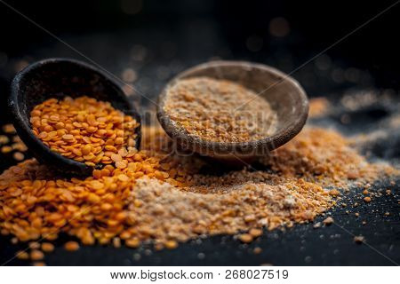 Close Up Of Raw Pink Lentils In A Clay Bowl On Wooden Surface With Its Powder.