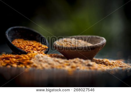 Close Up Of Raw Pink Lentils In A Clay Bowl On Wooden Surface With Its Powder.