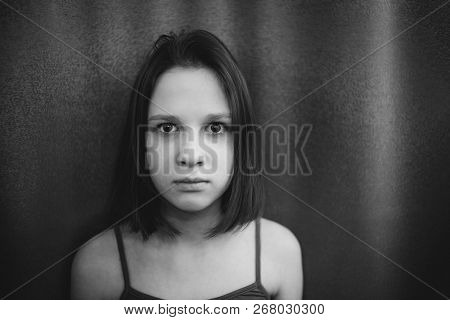 Unhappy, Saddened  And Depressed Little Girl With Expressive Eyes Close-up On Curtain Background. Mo