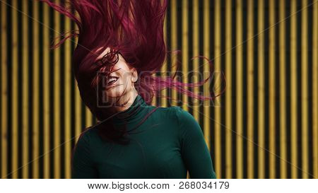 Cute Young Girl Dancing On Background Of Simple Geometric Pattern. Girl Has Eggplant Hair Flying In 