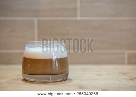 Multilayer Coffee Or Cappuccino In A Glass Cup On Wooden Table