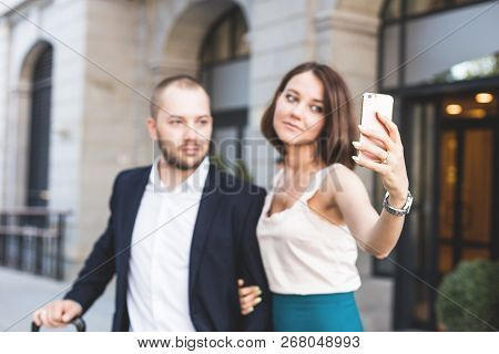 Elegant Business Couple Sitting With Phone And Book At The Waiting Hall In The Airport. Business Tra