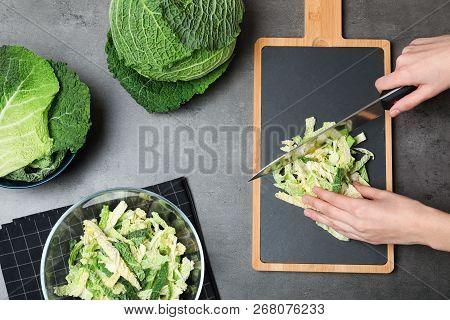 Woman Cutting Savoy Cabbage On Board At Table, Top View