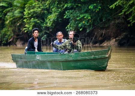 05 October 2013 Sabah. Borneo. Malaysia. A Photographer With A Long Lens Travels By Boat Along The K