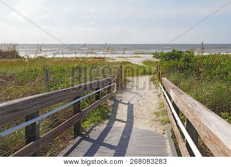 Entrance To The Beach At Sanibel Island, Florida Through Sea Oats And Other Vegetation On A Slightly