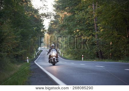 Bearded Biker In Sunglasses, Helmet And Black Leather Clothing Riding Modern Powerful High-speed Mot