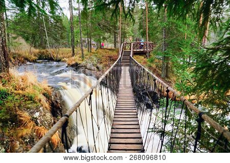 Suspended Pedestrian Bridge Over A Waterfall On The Tohmajoki River.