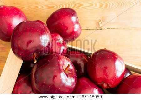 Red Juicy Ripe Apples In A Wooden Crate, The Box Is On The Boards