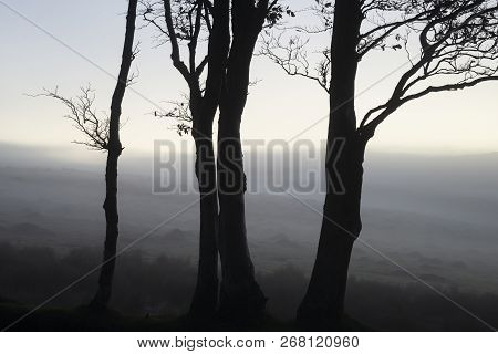 Stunning Foggy Sunrise Landscape Over The Tors In Dartmoor Revealing Peaks Through The Mist