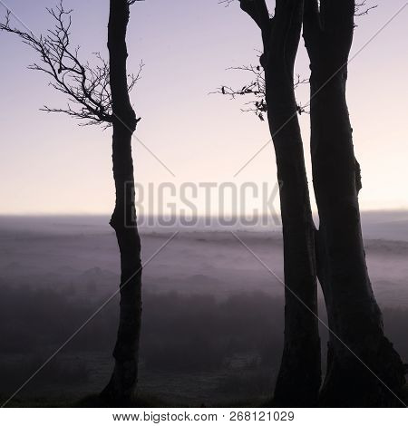 Stunning Foggy Sunrise Landscape Over The Tors In Dartmoor Revealing Peaks Through The Mist