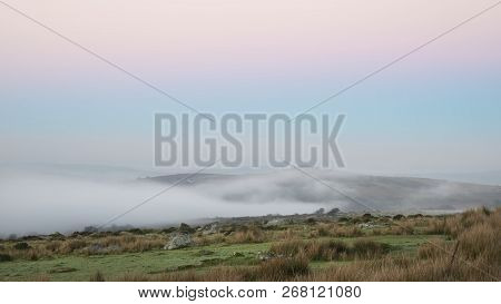 Stunning Foggy Sunrise Landscape Over The Tors In Dartmoor Revealing Peaks Through The Mist