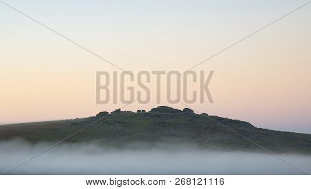 Stunning Foggy Sunrise Landscape Over The Tors In Dartmoor Revealing Peaks Through The Mist