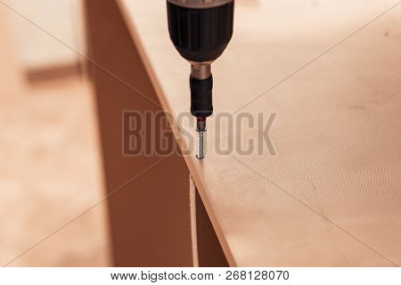 Manual Assembly Of Furniture. Electric Screwdriver With Bit Holder. Self-tapping Screw.