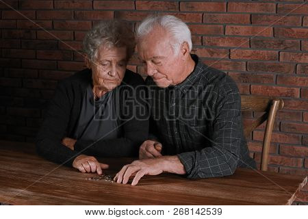 Poor Elderly Couple Counting Coins At Table