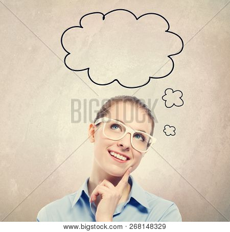 Young Woman In A Thoughtful Pose On A Brwon Wall Background