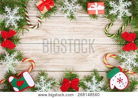 Christmas Frame Made Of Fir Branches Decorated With Snowflakes, Baws, Candy Canes And Boxes On A Lig