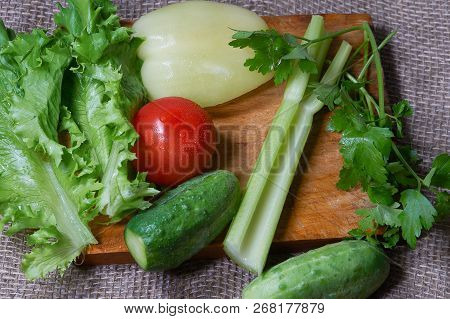 Salad, Tomatoes, Peper, Cucumbers, Smallage And Parsley On Cutting Board