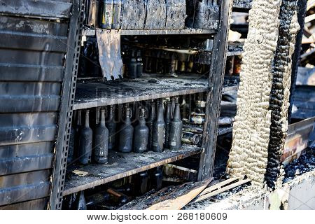 Close Up Damaged Supermarket Glass Plastic Bottles On Shelves After Arson Fire With Burn Black Dark 