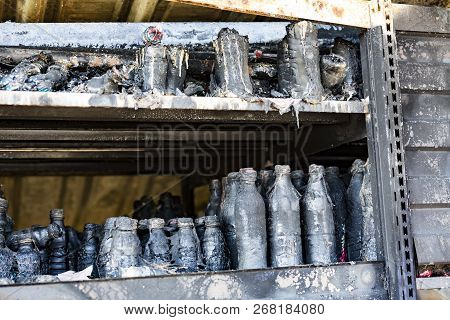 Close Up Damaged Supermarket Glass Plastic Bottles On Shelves After Arson Fire With Burn Black Dark 
