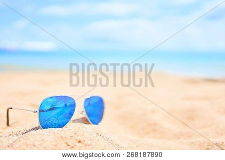 Blue Sunglasses On Sand Beach. Vacation Concept