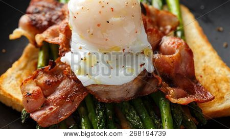 Benedict Poached Duck Egg With Crispy Bacon And Fried Asparagus On Toasts For Breakfast